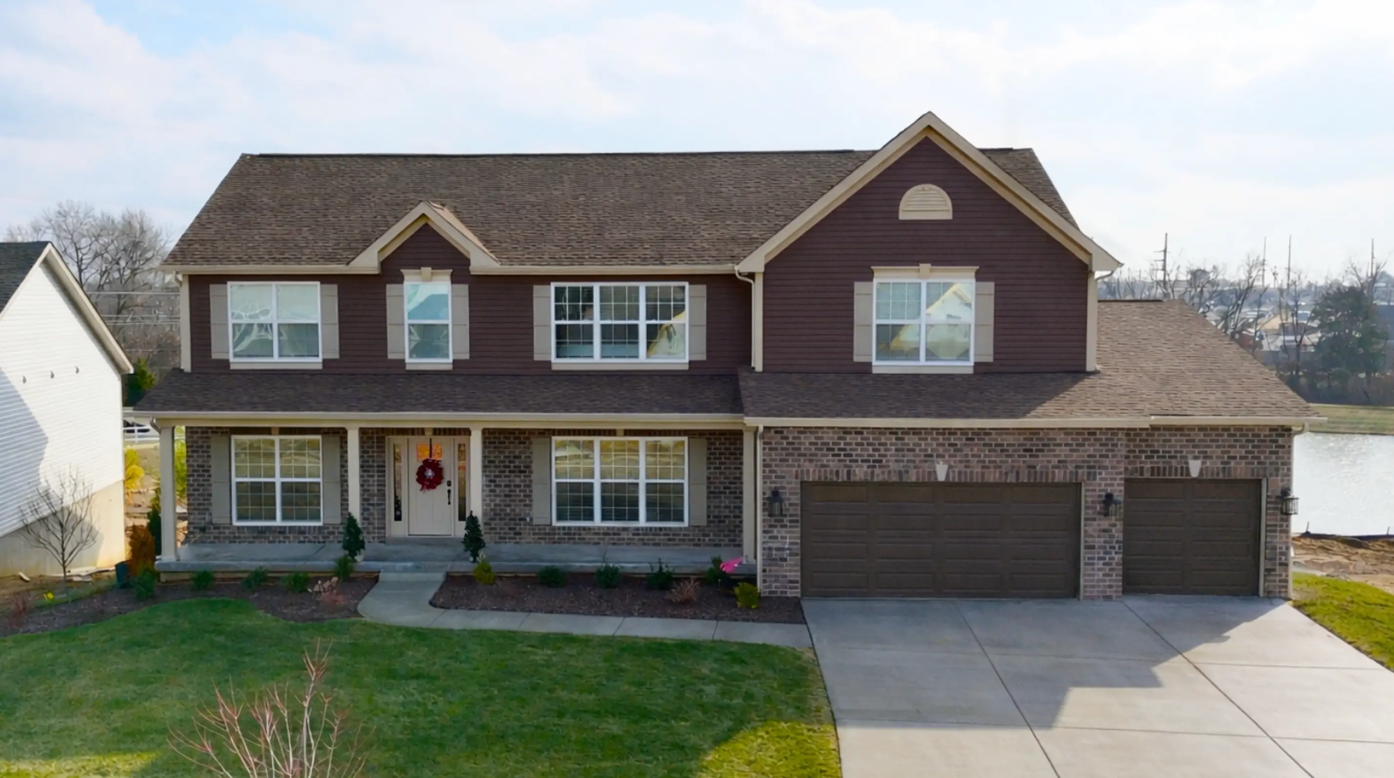 116 Royal Troon — two-story brick-and-siding home on a waterfront lot.