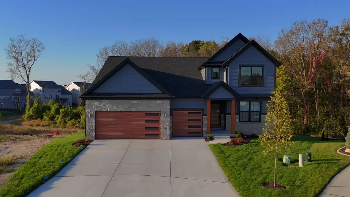 New Madison II by McKelvey at Cottleville Trails — two-story siding home with stone-and-wood accents.